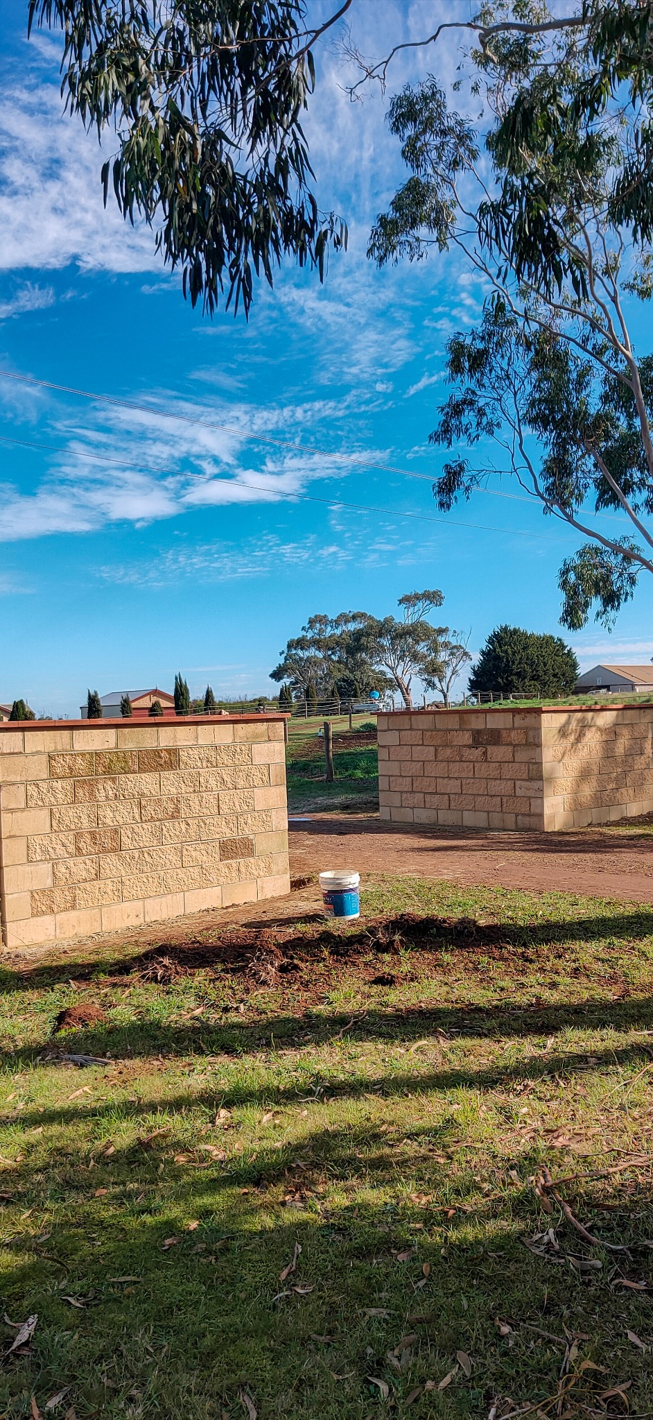 Completed tan brick wall and landscaped yard